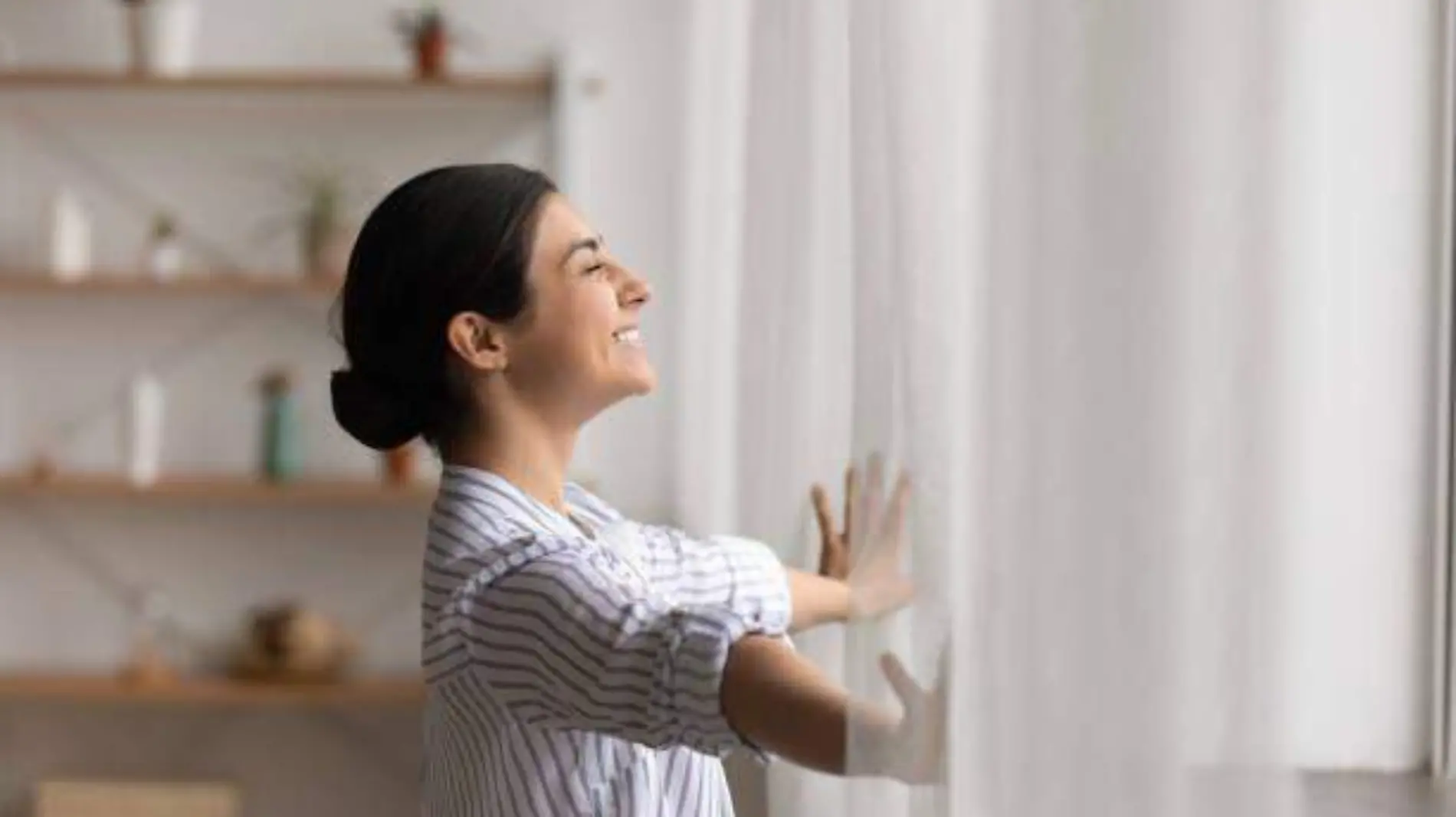 MUJER ABRIENDO CORTINAS